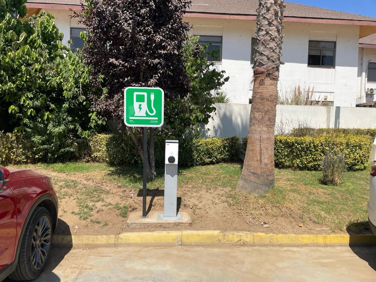 Punto de carga para autos eléctricos en el estacionamiento del resort, señalizado y junto a las habitaciones